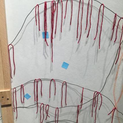 viewers were invited to add ancestor and family prayers by draping red string on the rippling black wires